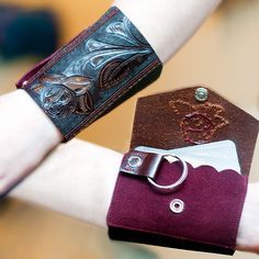 a woman's arm with a leather cuff and ring on it