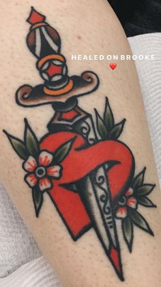 a woman with a tattoo on her arm holding a knife and flowered hat in front of her head