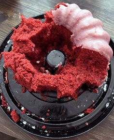 a red cake sitting on top of a black plate