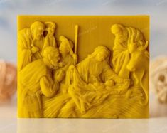 a yellow soap with an image of the birth of jesus and three children on it