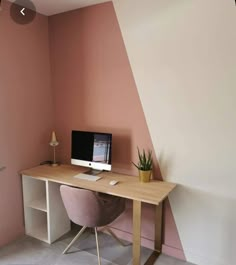 a desk with a computer on it and a potted plant in front of it