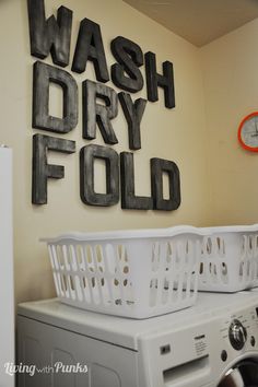 a washer and dryer sitting next to each other in front of a sign