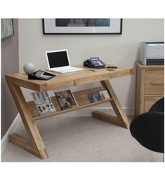 a laptop computer sitting on top of a wooden desk next to a phone and printer