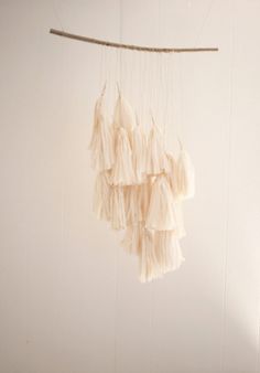 a white wall hanging with some tassels on it