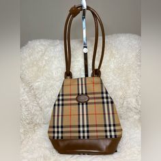 Description Burberry's Bucket Bag Vintage Brown Canvas Plaid Print Gold-Tone Hardware Dual Shoulder Straps Leather Trim Embellishment Canvas Lining & Dual Interior Pockets Snap Closure At Top Details: Depth: 5" Width: 8.75" Shoulder Strap Drop: 10" Height: 10.5" This Item Is Vintage And Is Authentic. Minor Rubs At The Bottom Piping And One Light Scratch As Seen In Picture. Inside Is Clean And No Stain Noted. Burberry Horseferry Bag, Burberry Bucket Bag, Burberry Handbags, Brown Canvas, Plaid Print, Burberry Bag, Vintage Brown, One Light, Leather Trims