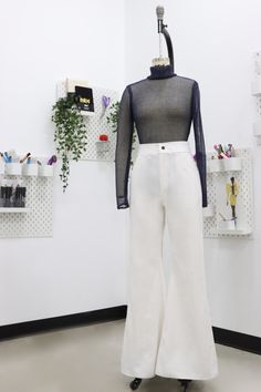 a mannequin is standing in front of a white wall