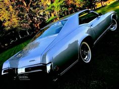 a silver car parked on top of a lush green field