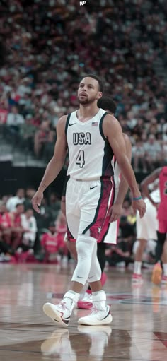 a basketball player walking on the court with his foot in the air and people watching