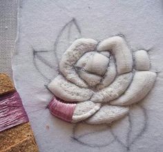 a close up of a piece of art on a table next to thread and scissors