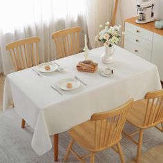 the table is set for two with plates and silverware on it, along with flowers