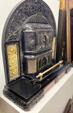 an old fashioned stove sitting on top of a white mantle next to other antique items