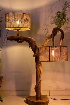 a lamp that is on top of a wooden stand next to a potted plant