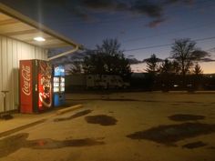 an empty gas station at night with the sun setting