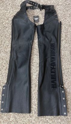 These vintage Harley-Davidson leather motorcycle chaps are a must-have for any rider. Made with high-quality leather, they are windproof and water-resistant, ensuring comfort and protection during all seasons. The adjustable belt ensures a perfect fit, while the four pockets provide ample storage space. The black color and visible Harley-Davidson logo make these chaps a stylish addition to any outfit. Perfect for women in size XS, these regular-sized chaps are ideal for any motorcycle enthusiast