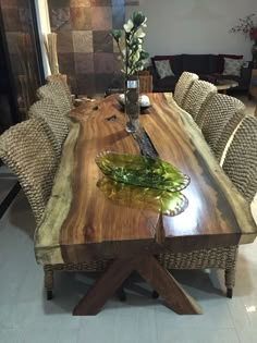 a dining table made out of wood and wicker with chairs around it in a living room