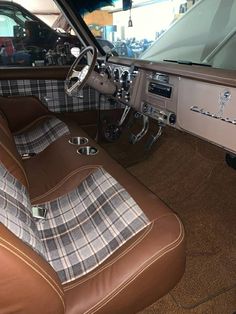 the interior of an old car with leather and plaid upholstered seat covers on it