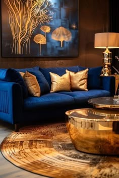 a living room filled with blue couches and gold pillows in front of a painting