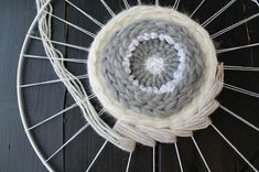 the yarn is white and gray on the spoke of a spinning wheel, which has two skeins attached to it