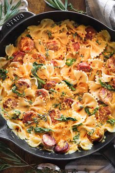 a skillet filled with pasta and sausage