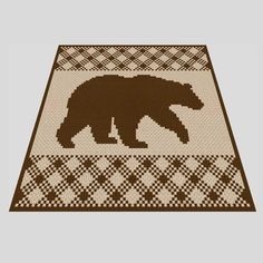 a brown bear rug on top of a white tablecloth with black and tan patterns