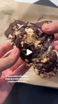 a person holding a chocolate covered doughnut with nuts on it's side and the words if you want a healthy high protein stickers recipe