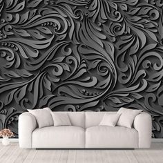 a couch sitting in front of a wall covered in black and white art nouveau designs