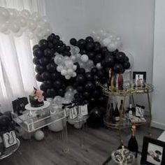 a room filled with black and white balloons