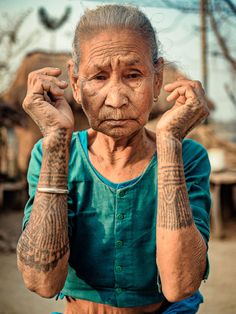 an old woman with tattoos on her arms