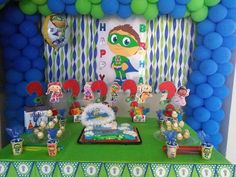 the birthday party is decorated with green and blue balloons, paper garlands, and decorations