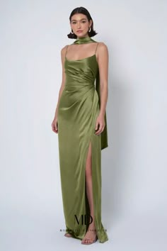 a woman in a long green dress with a slit down the side and one leg