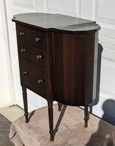 an old wooden cabinet sitting in front of a garage door