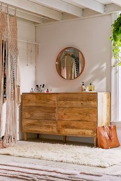 a bedroom with a dresser, mirror and hanging hammock