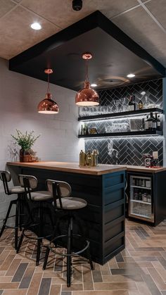 a bar with three stools in front of it and some shelves on the wall