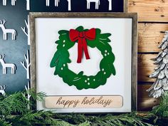 a christmas card with a green wreath and red bow hanging from it's center