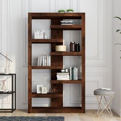 a book shelf with books on it in a room next to a chair and table