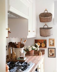 the kitchen counter is clean and ready to be used as a cooktop, with baskets hanging on the wall