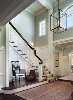 the stairs in this house have been decorated with black and white accents, while the light fixture