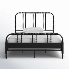 a black metal bed frame with white sheets and pillows on the bottom, against a plain background