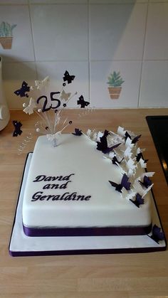 a white cake with purple and black butterflies on it