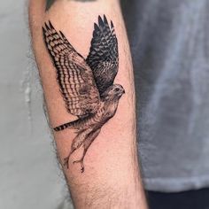 a black and white bird tattoo on the arm