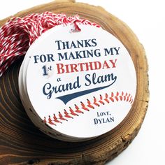 a baseball themed birthday ornament on top of a piece of wood that says thanks for making my 1st birthday a grand slam