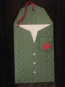 a green cardigan with a red heart hanging from it's front and back