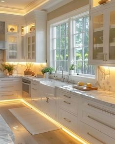 a kitchen filled with lots of white cabinets and counter top space next to a window