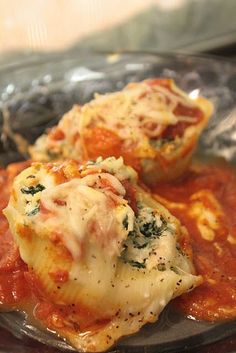 two stuffed shells covered in sauce and cheese