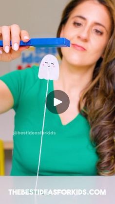 a woman holding up a toothbrush with a fake smile on it