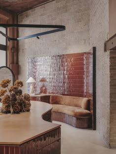 a living room filled with furniture next to a brick wall