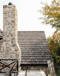 an old stone building with a chimney and tiled roof