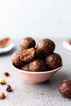 a bowl filled with chocolate energy bites next to nuts