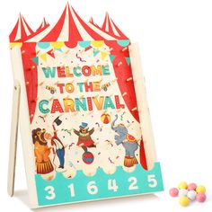 a wooden carnival sign with candy in front of it and a circus tent behind it