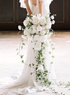 a woman in a wedding dress holding a bouquet of flowers